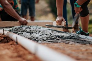  Workers Laying Cement showing US Cement Production Soars in 2022