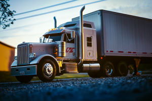 Close‐up, low‐angle view of a polished silver semi‐truck with tall exhaust stacks and “LFC” on the side, coupled to a matching box trailer.