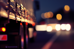 Close-up of a truck’s tarp and lights at night, with soft bokeh highlights in the background.
