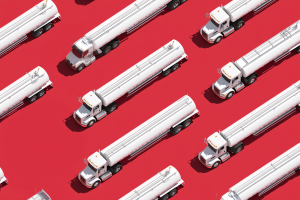 Tank Fleet Compliance Update: Essential 11-Point Guide for March 23, 2026 2 Pattern of white stainless-steel tank trucks arranged diagonally across a bright red background in an isometric overhead illustration.
