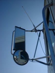 Roadcheck ELD Enforcement: 12 Major Enforcement Risks for Fleets in 2026 5 Close-up view from a truck cab mirror showing part of the day cab and pneumatic tank equipment.Title: Driver-side mirror and tank detail