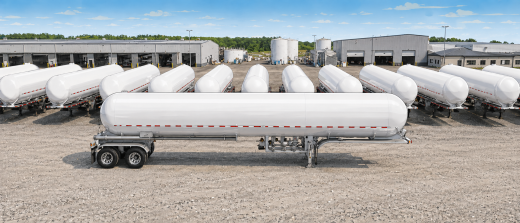 Illustrated wide aerial view of multiple white MC 331-style LPG cargo tank trailers lined up in an industrial yard, with warehouses and storage tanks in the background.