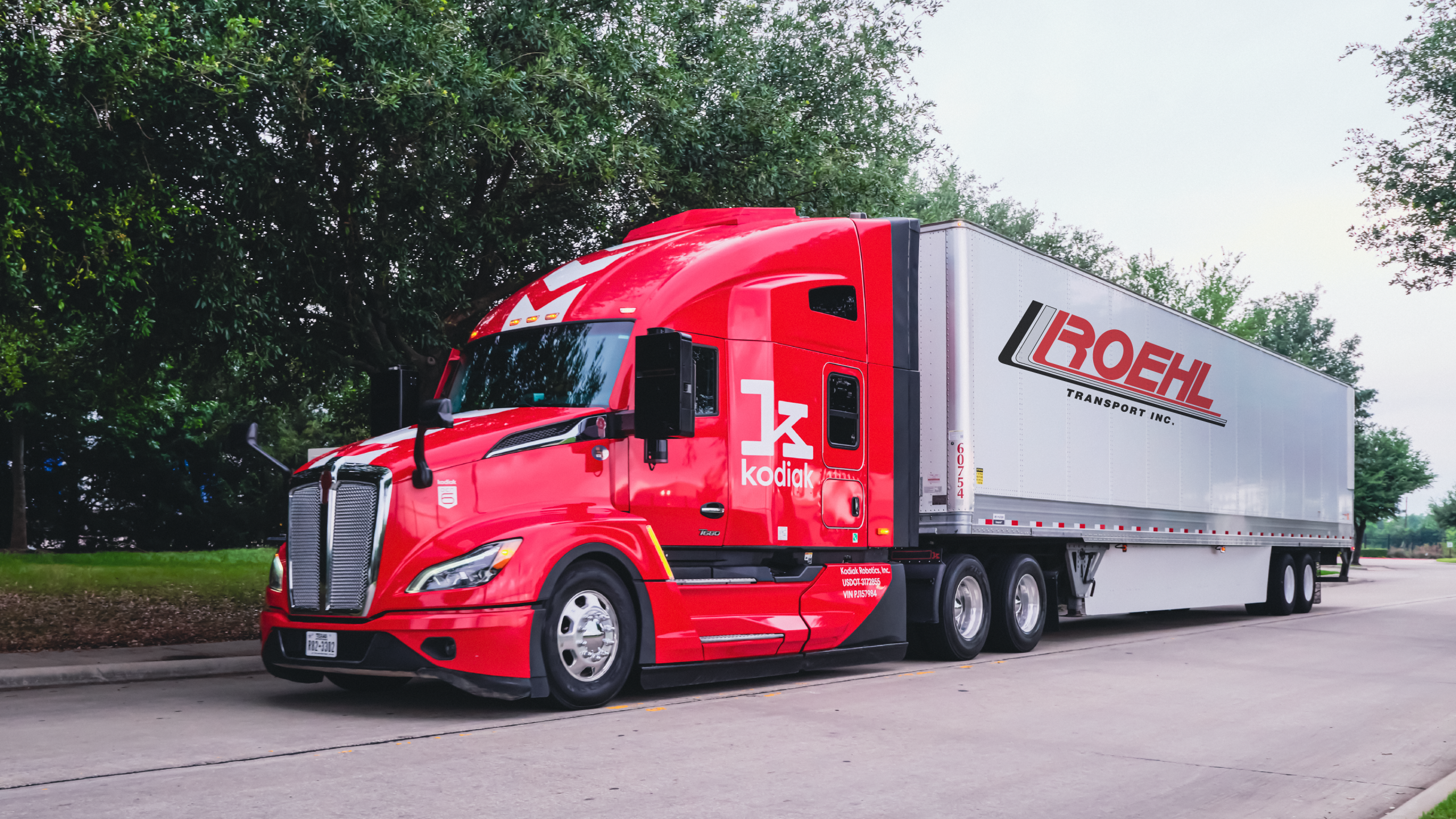 Autonomous trucking expansion with Kodiak AI tractor hauling Roehl Transport trailer. Kodiak AI autonomous tractor hauling a Roehl Transport dry van trailer on a roadway.