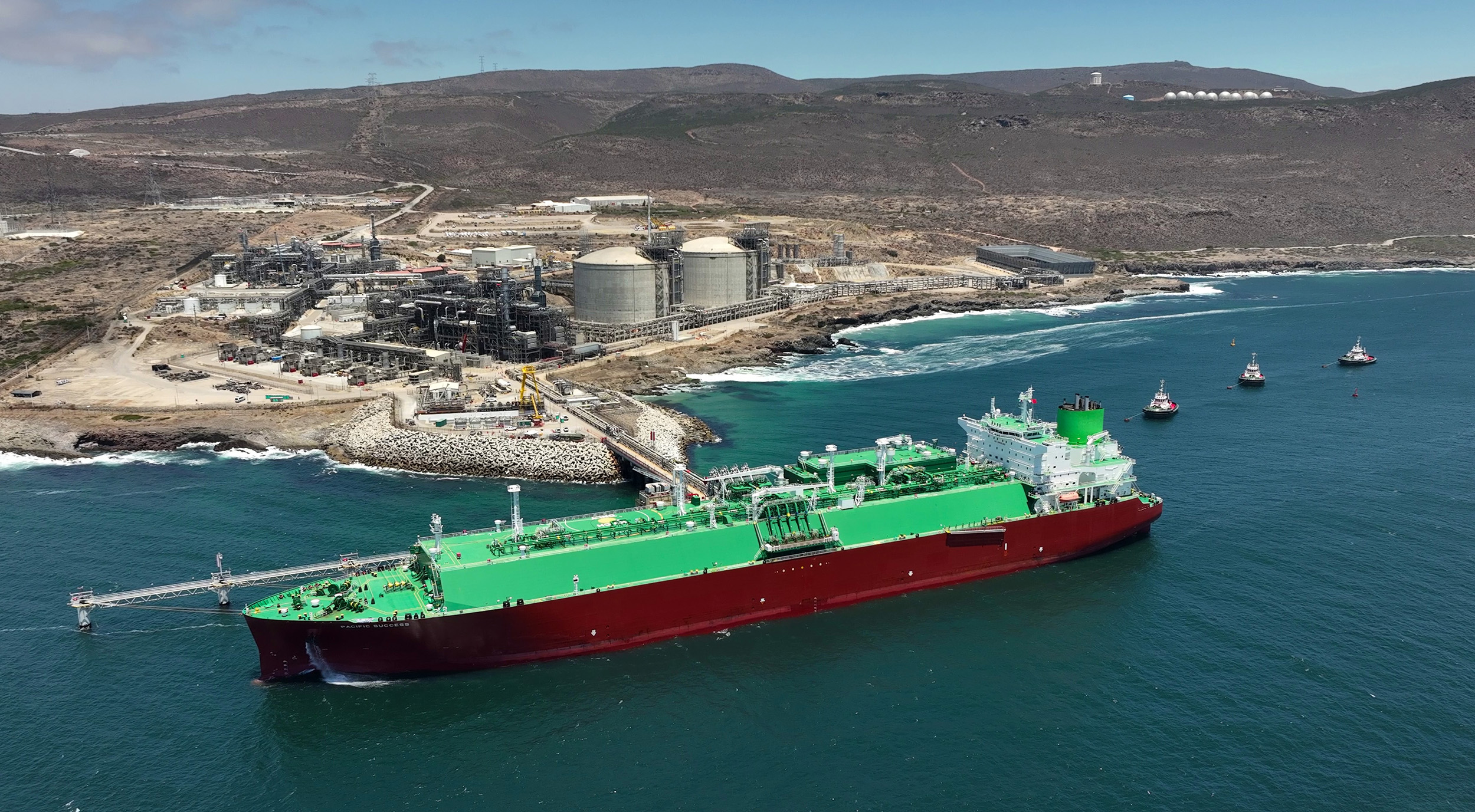 LNG carrier and tugboats offshore from Energía Costa Azul LNG during the terminal’s first commissioning cargo.