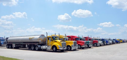 Full view of rows of fuel tanker trucks staged on an airfield tarmac in Texas.