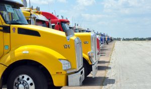 Texas Flood Declaration Opens Limited HOS Relief for Emergency Haulers 1 Rows of fuel tanker trucks staged on an airfield tarmac in Texas.