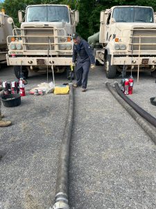FMCSA Motus Registration: 9 Powerful Changes With Cautious Upside for Carrier Identity 13 Quality assurance representative inspecting military fuel tanker trucks and hoses.