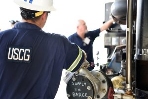 Coast Guard Proposes Nationwide Tank-Barge Inspection Flexibilities 8 Coast Guard marine inspector in a hard hat beside barge equipment labeled “Supply to Barge” during hands-on training