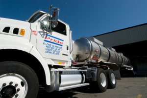 EMCO Deal Would Add Northeast Chemical Distribution and Bulk Delivery Operations 3 White Pride Chemical Solutions tractor and stainless-steel tank trailer parked beside an industrial building.
