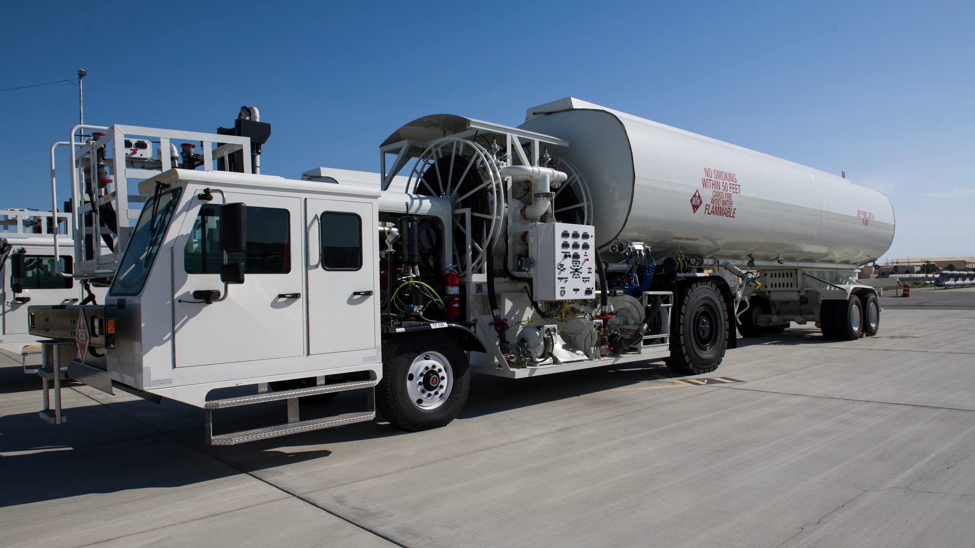 White Stephens aircraft refueler with exposed pumping equipment, hose reels and a large fuel tank at Edwards Air Force Base.