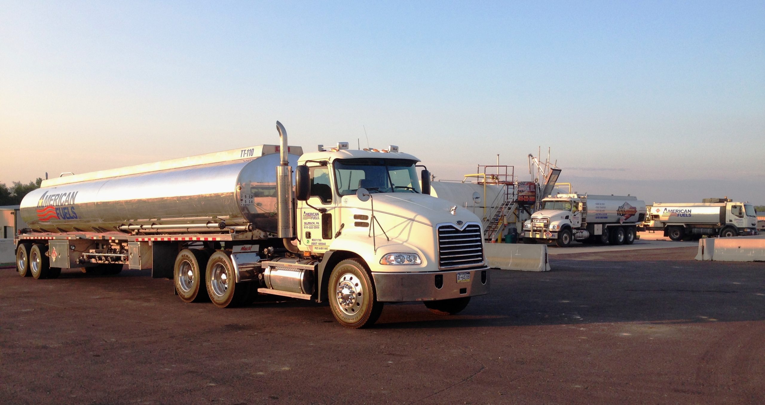 White American Fuels Mack tractor with a polished petroleum tank trailer parked in a fleet yard.