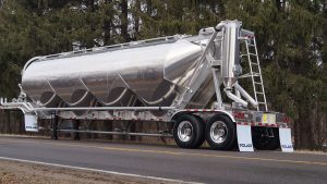 Polar Previews New Dry-Bulk Trailer Ahead of Tank Truck Week 1 Silver Polar large-cube dry-bulk trailer parked beside trees, with four hoppers, a rear ladder and tandem axles.