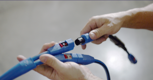 FMCSA Reopens Comments on Radar-Triggered Rear-Collision Warning Lights 4 Hands holding blue connectors on a Grote 4SEE digital wiring harness