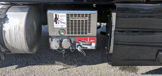 Paragon HydraCHEM system mounted beside a truck’s fuel tank, with controls, a pressure gauge, and capped hose connections visible.