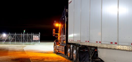 Amber cab-mounted warning beacon illuminated on an Aurora-equipped Peterbilt tractor at night.